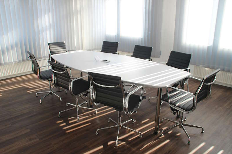Una sala de reuniones en la que vemos una mesa alargada con 8 sillas